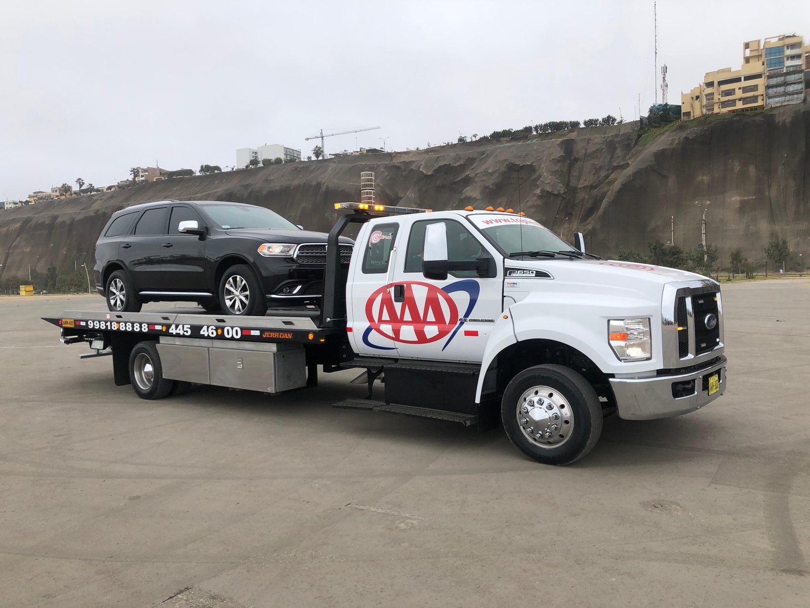 Grúa plataforma trasladando una camioneta Dodge Durango en Lima
