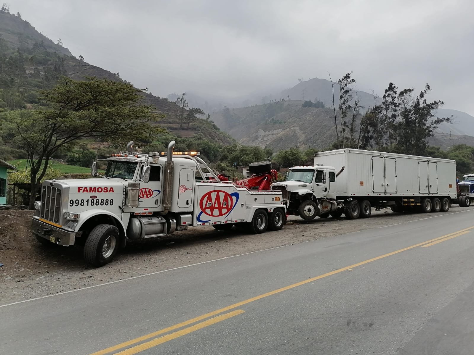 Grúa para camiones remolcando un tracto en carretera de sierra
