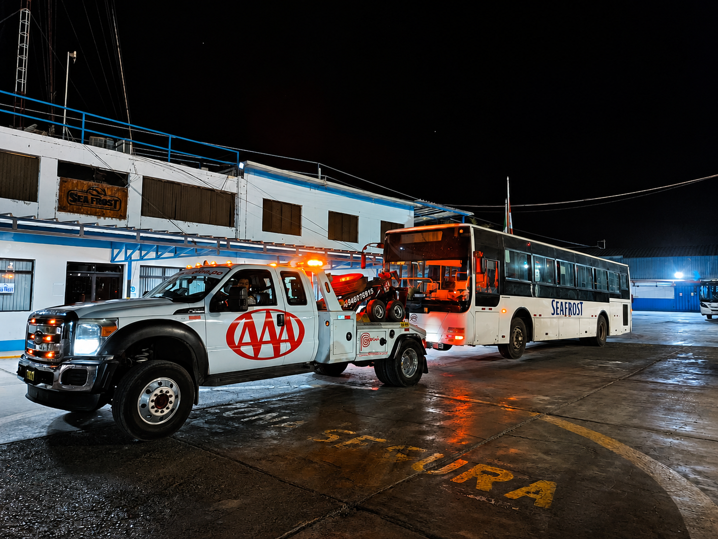 Unidad de Grúas Triple A remolcando un bus de noche en Paita