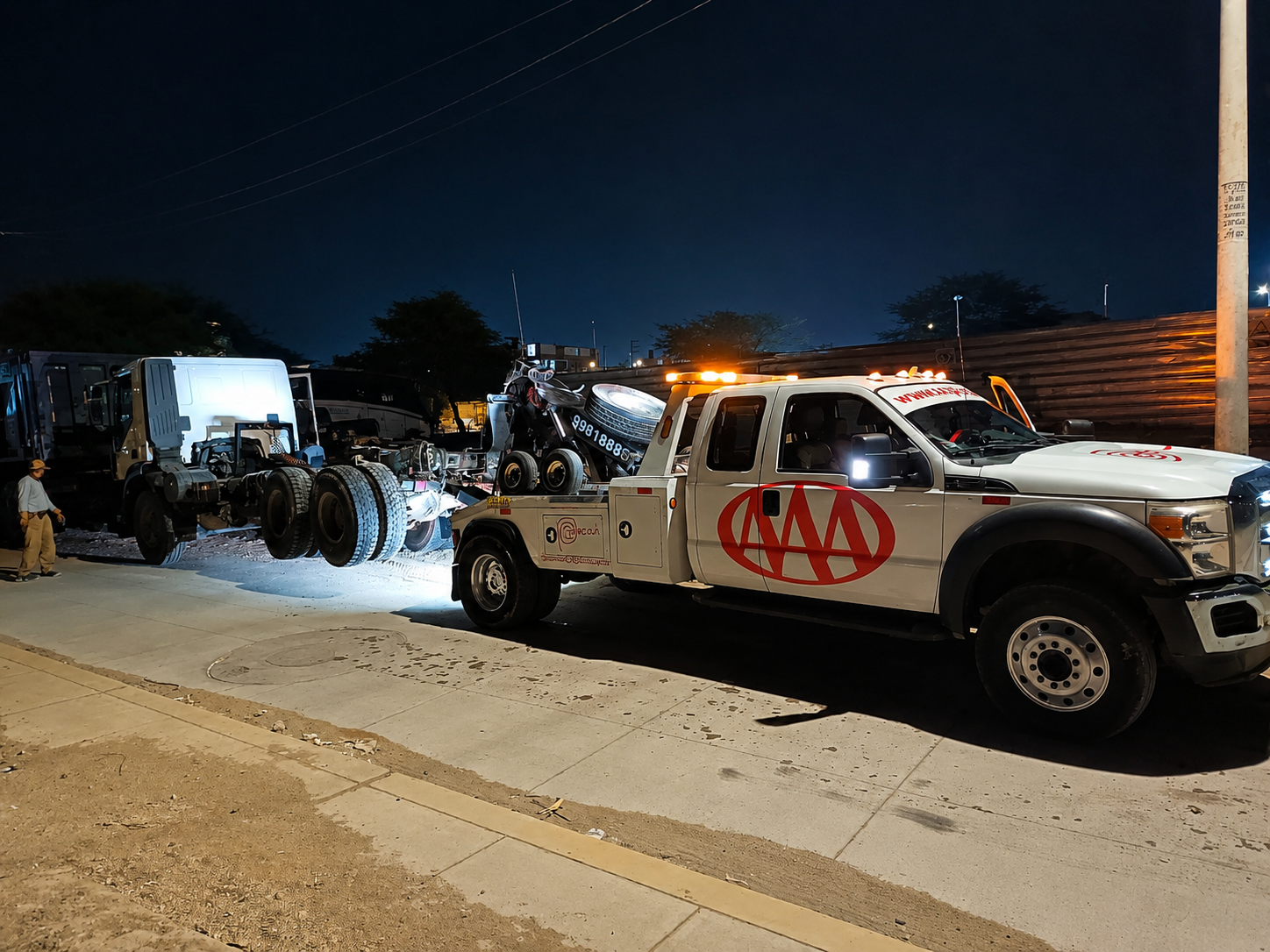 Grúa Triple A trabajando de madrugada sobre un tracto sin cabina en Piura