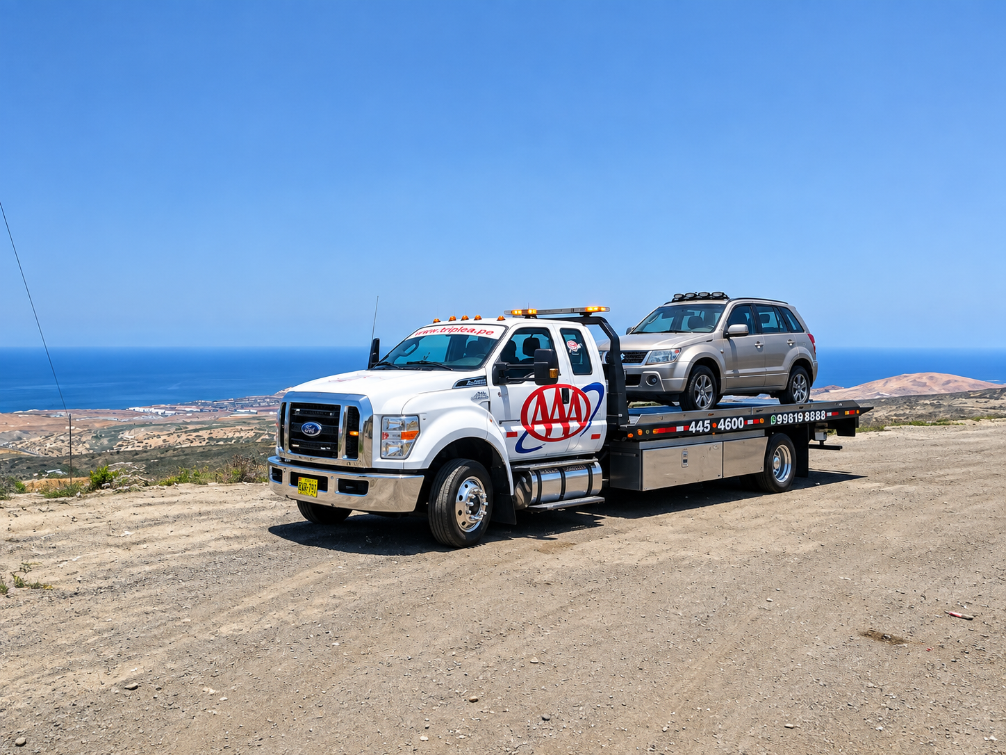 Grúa plataforma trasladando una camioneta frente al mar