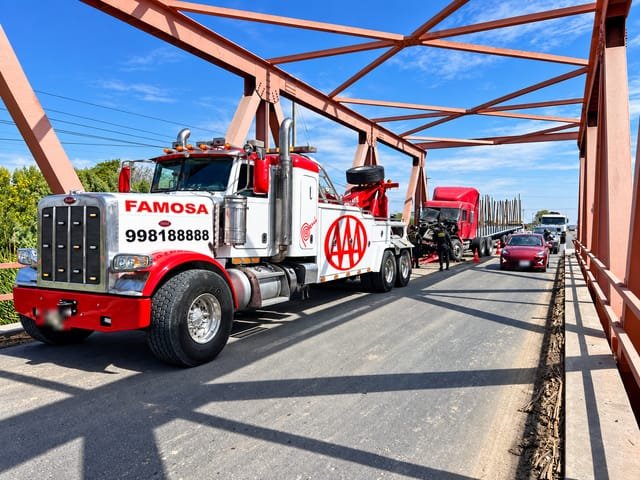 Grúa pesada Peterbilt en ruta cruzando un puente metálico