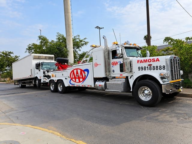 Grúa pesada Peterbilt remolcando un camión furgón