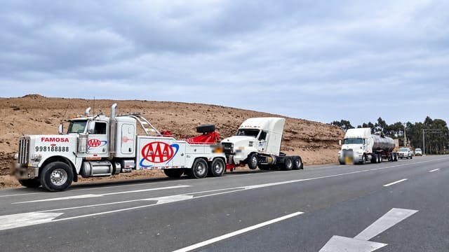 Grúa pesada Peterbilt remolcando un tracto por carretera