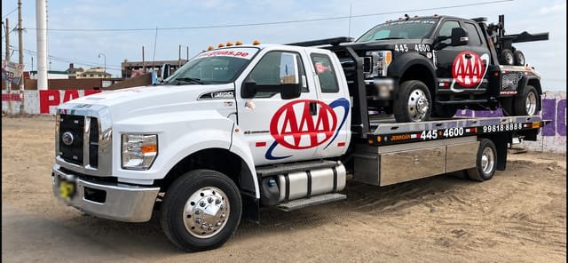 Grúa plataforma F-650 de Grúas Triple A con una camioneta negra encima