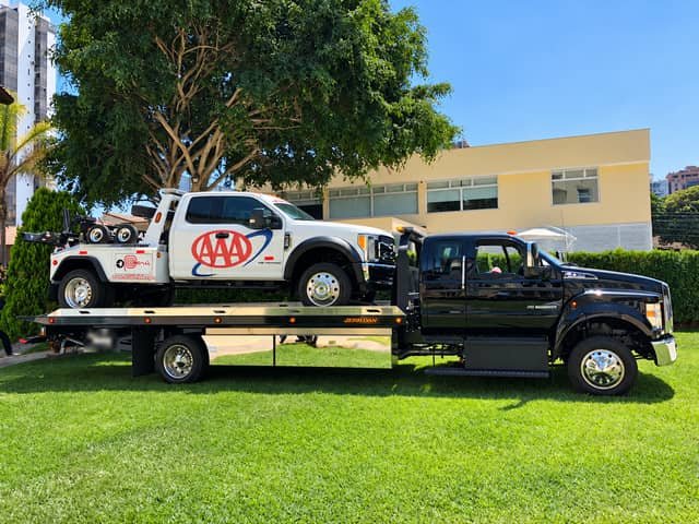 Grúa plataforma Ford F-650 de Grúas Triple A trasladando otra unidad de la flota