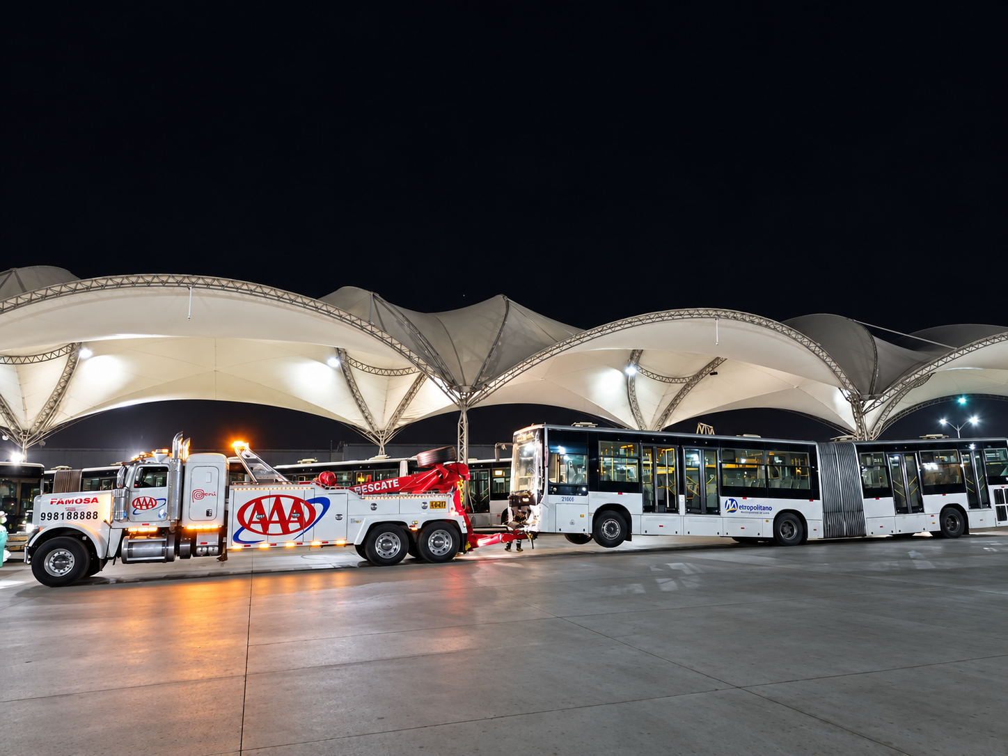 Grúa Triple A retirando de noche un bus articulado del Metropolitano en Lima